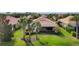 Backyard view showcasing the home's screened-in lanai, lush lawn, and mature palm trees at 19138 Kirella St, Venice, FL 34293