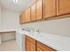 Well-equipped laundry room with ample cabinet space, a utility sink, and a countertop for folding at 19138 Kirella St, Venice, FL 34293