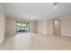Open-concept living room with tile floors, neutral walls, and sliding glass doors at 19138 Kirella St, Venice, FL 34293
