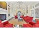 Welcoming lounge area with comfortable red seating, a cozy fireplace, tall columns, and a library at 19138 Kirella St, Venice, FL 34293