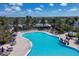 Large community pool featuring lounge chairs, umbrellas, and tropical landscaping in the IslandWalk neighborhood at 19138 Kirella St, Venice, FL 34293