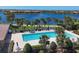 Aerial view of lap pool surrounded by palm trees and lounge chairs near a scenic lake in IslandWalk community at 19138 Kirella St, Venice, FL 34293