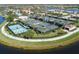 Aerial view of green tennis courts with blue shades and players, surrounded by lush landscaping and a nearby lake at 19138 Kirella St, Venice, FL 34293