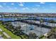 Scenic view of tennis courts featuring blue shades, surrounded by lush landscaping, a lake, and residential homes at 19138 Kirella St, Venice, FL 34293