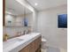 Bright bathroom showcasing a double vanity with gold fixtures, a large mirror, and tile flooring at 238 Island Cir, Sarasota, FL 34242