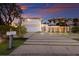 Beautiful home with a lush, grassy driveway and palm trees, set against a vibrant sunset sky at 238 Island Cir, Sarasota, FL 34242