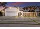 Stunning modern home featuring a well-manicured lawn, sleek design, and a beautiful sunset backdrop at 238 Island Cir, Sarasota, FL 34242