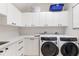Clean laundry room with washer, dryer, white cabinets, and ample counter space for folding at 238 Island Cir, Sarasota, FL 34242