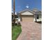 A charming home with a brick drive, tan garage door, and well maintained landscaping at 240 Ibiza Loop, Venice, FL 34292