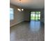 A spacious living room with wood tile flooring and sliding glass doors to the lanai at 240 Ibiza Loop, Venice, FL 34292