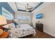 Inviting bedroom with blue accent wall, tray ceiling, and a view from the window at 241 Sapphire Lake Dr # 201, Bradenton, FL 34209