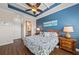Bright bedroom with blue accent wall, tray ceiling, and en-suite bathroom access at 241 Sapphire Lake Dr # 201, Bradenton, FL 34209