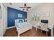 Coastal-themed bedroom featuring a blue accent wall, ceiling fan, and a window with white shutters at 241 Sapphire Lake Dr # 201, Bradenton, FL 34209