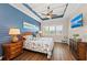 Beautiful bedroom with blue accent wall, tray ceiling, and a comfortable bed with floral bedding at 241 Sapphire Lake Dr # 201, Bradenton, FL 34209