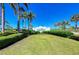Welcoming entrance to The Beach Club with lush landscaping, manicured lawn and clear blue sky at 241 Sapphire Lake Dr # 201, Bradenton, FL 34209