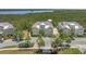 Beautiful townhouse with neutral tones, lush landscaping, and a view of the water and trees in the background at 241 Sapphire Lake Dr # 201, Bradenton, FL 34209