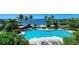 Wonderful pool area with lounge chairs and beautiful views of the bay, blue sky, and trees at 241 Sapphire Lake Dr # 201, Bradenton, FL 34209