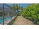 The backyard has a spacious screened-in pool enclosure and is adjacent to lush landscaping and a lawn area at 301 Angelico Dr, Nokomis, FL 34275