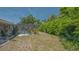 View of pool enclosure from backyard; lush plants and trees provide shade and privacy at 301 Angelico Dr, Nokomis, FL 34275