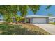 Charming single-story home with a well-manicured lawn, mature landscaping, and an attached two-car garage at 301 Angelico Dr, Nokomis, FL 34275