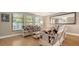 Bright living room with large windows, neutral decor, and wood flooring at 301 Angelico Dr, Nokomis, FL 34275
