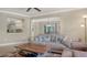 Comfortable living room featuring a sofa, a table, and a view of the kitchen and dining area at 301 Angelico Dr, Nokomis, FL 34275