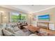 Comfortable living room with a plush sofa, cozy armchair, large window, and a mounted television at 301 Angelico Dr, Nokomis, FL 34275