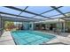 A refreshing screened-in pool is surrounded by ample patio space and overlooks the landscaped backyard at 301 Angelico Dr, Nokomis, FL 34275