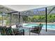 Beautiful screened-in pool area with comfortable seating and lush tropical surroundings at 301 Angelico Dr, Nokomis, FL 34275