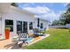 Charming backyard patio with modern seating, colorful outdoor rug, and lush landscaping at 3090 6Th St, Sarasota, FL 34237