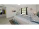 Comfortable bedroom features neutral decor, a mounted TV, and a window overlooking lush greenery at 3090 6Th St, Sarasota, FL 34237