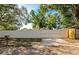 Street view of a modern residence featuring a white fence, automatic gate, and well-manicured landscaping at 3090 6Th St, Sarasota, FL 34237