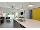 Open-concept living area features a kitchen island, pendant lighting, and seating with access to the backyard at 3090 6Th St, Sarasota, FL 34237