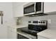 Close-up of modern kitchen appliances, including a stainless steel microwave and electric range at 3090 6Th St, Sarasota, FL 34237