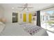 Bright main bedroom featuring sliding glass doors, ceiling fan, and ensuite bathroom at 3090 6Th St, Sarasota, FL 34237