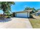 Home exterior featuring a two-car garage, green trim, and large driveway at 3336 Pembrook Dr, Sarasota, FL 34239