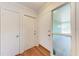 Bright foyer featuring wood-look flooring, multiple closets, and a frosted glass window for privacy and natural light at 3336 Pembrook Dr, Sarasota, FL 34239