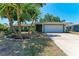 Charming single-story home with a well-manicured lawn, complemented by a lush tropical landscaping at 3336 Pembrook Dr, Sarasota, FL 34239