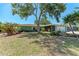 Charming single-story home featuring beautiful landscaping and a large shade tree in a well-maintained front yard at 3336 Pembrook Dr, Sarasota, FL 34239