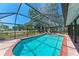 Sparkling pool with screened enclosure, brick border, and spacious backyard for outdoor enjoyment and relaxation at 3336 Pembrook Dr, Sarasota, FL 34239