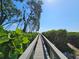 Charming boardwalk lined with lush greenery, leading towards the beach and ocean on a bright, sunny day at 3805 E Bay Dr # 302, Holmes Beach, FL 34217