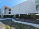 Bright condo building with stucco exterior, red roof, and well maintained landscaping in sunny weather at 3805 E Bay Dr # 302, Holmes Beach, FL 34217