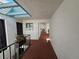 Well-lit condo hallway with brick flooring, white walls, a skylight and decorative plants in a pot at 3805 E Bay Dr # 302, Holmes Beach, FL 34217