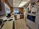 Functional kitchen with white appliances, wood cabinets, and a laminate floor at 3805 E Bay Dr # 302, Holmes Beach, FL 34217