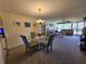 Open floor plan showcasing a combined living and dining area with a glass table, carpeted floors, and comfortable sofas at 3805 E Bay Dr # 302, Holmes Beach, FL 34217