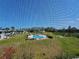 View through screen of a community pool surrounded by green space and condos in the background at 3805 E Bay Dr # 302, Holmes Beach, FL 34217
