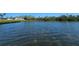 Picturesque waterfront featuring well-maintained lawns and white condos surrounded by lush greenery at 3805 E Bay Dr # 302, Holmes Beach, FL 34217