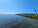 Scenic waterfront condos with lush greenery and a vibrant red tile roof on a sunny day at 3805 E Bay Dr # 302, Holmes Beach, FL 34217