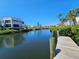 Beautiful waterfront condo buildings from a wooden dock overlooking a canal surrounded by tropical vegetation at 3805 E Bay Dr # 302, Holmes Beach, FL 34217