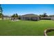 Spacious backyard with a screened patio featuring a hot tub and an outdoor fire pit for entertaining at 3889 Canopy Way, Sarasota, FL 34235